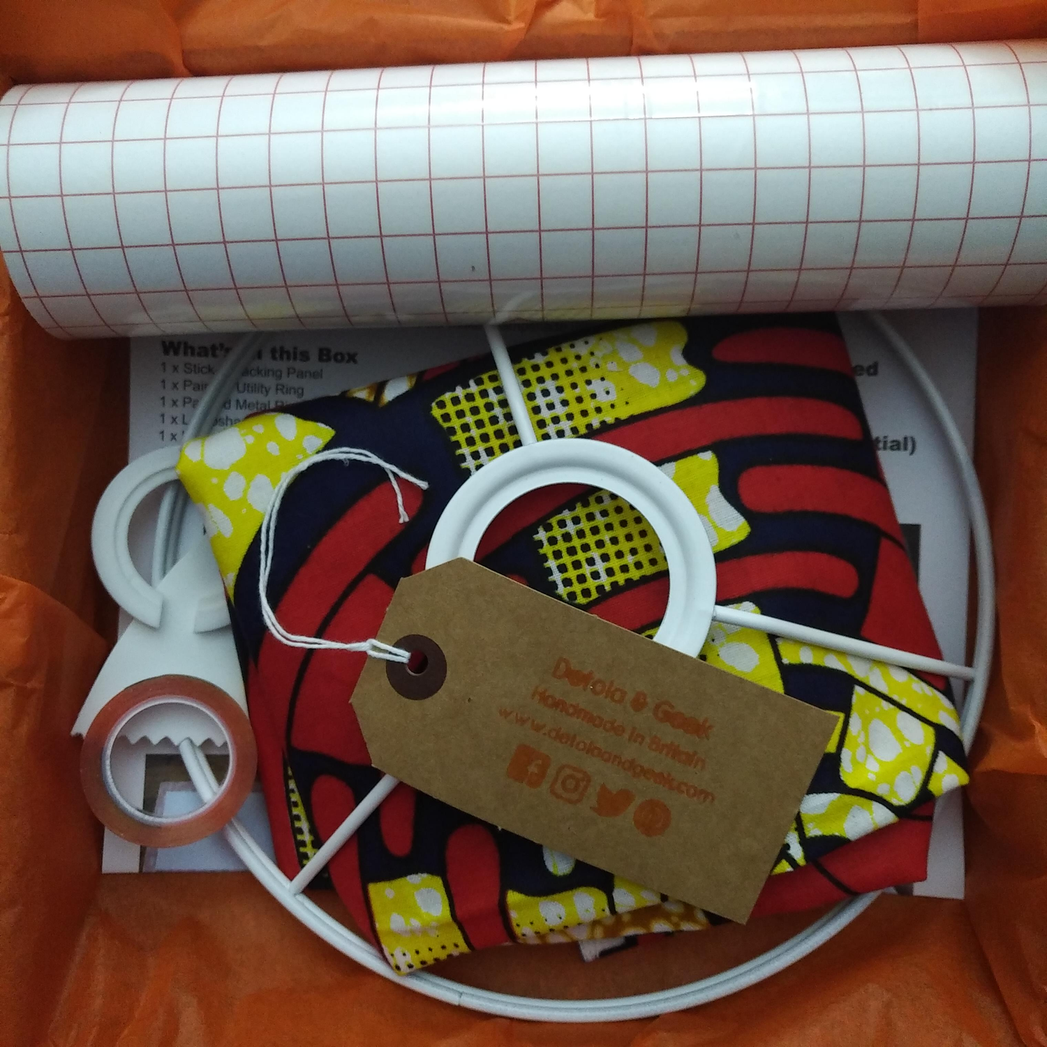 Drum lampshade craft making kit with a piece of African print fabric. There's another image of a paisley green rustic African print lampshade made by a Detola and Geek customer (Nido_Home) in situ. Surrounded by wall paintings and table decor objets.