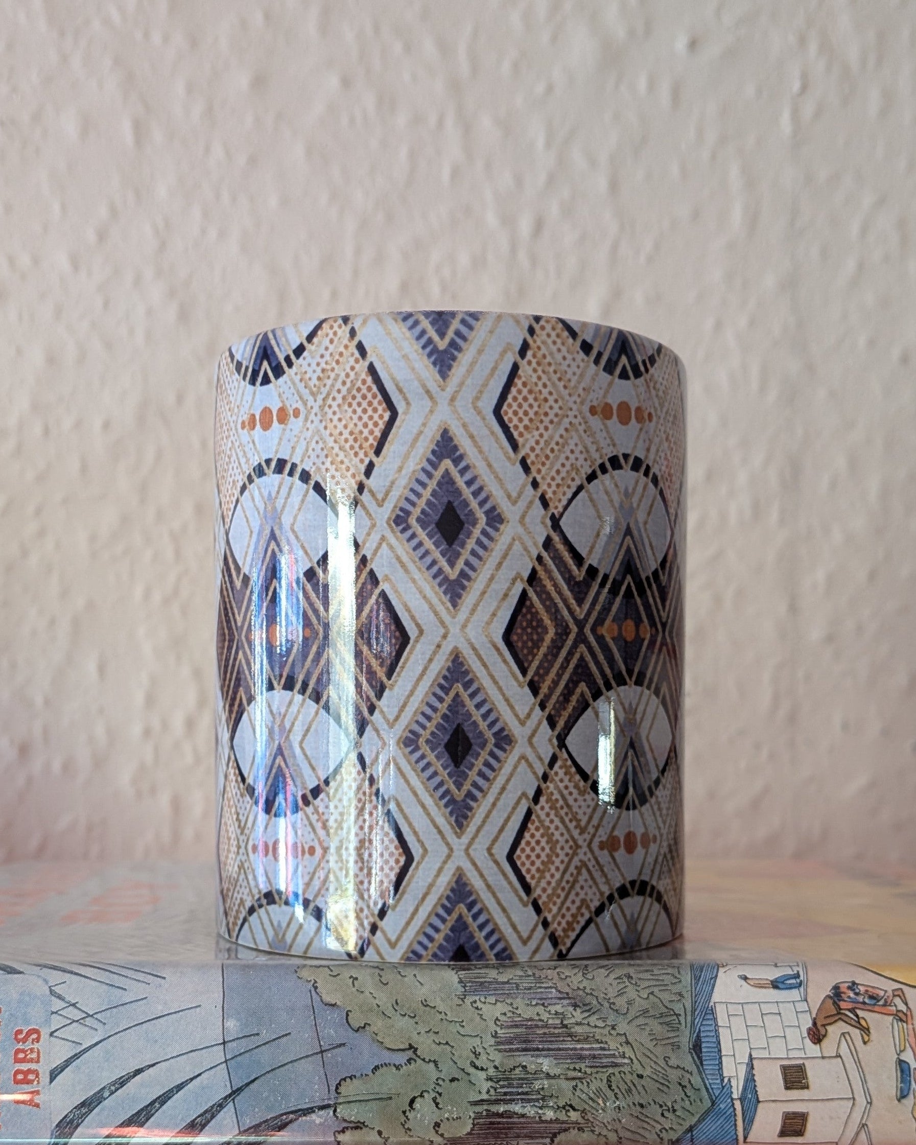 Decorative ceramic mug with geometric pattern on a textured surface