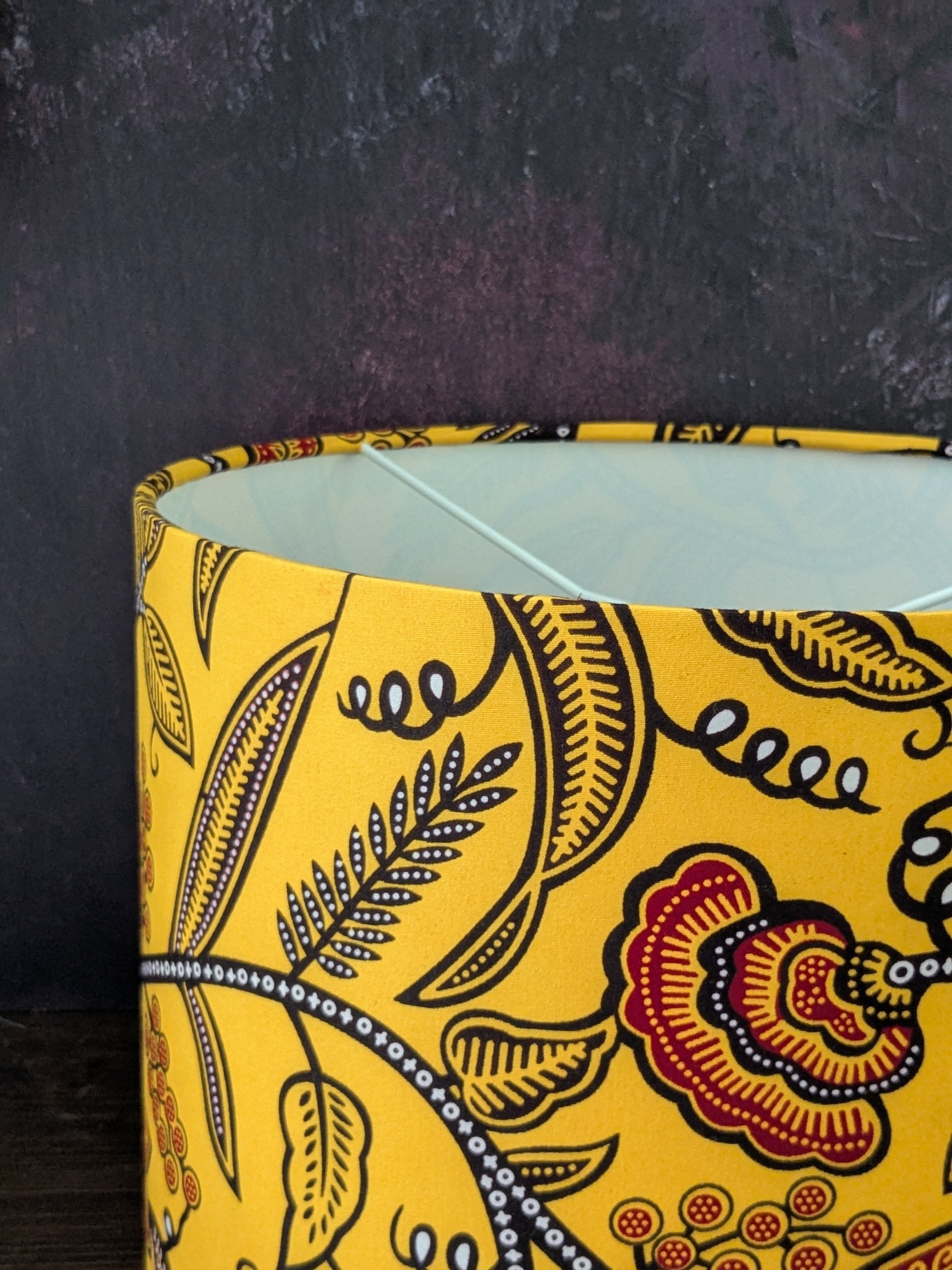 Yellow patterned lampshade on a dark background