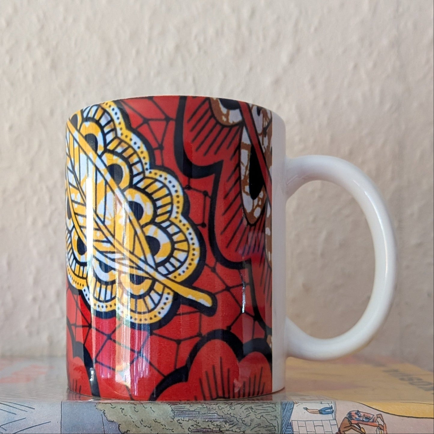 Copper yellow coloured mug with a paisley leaf design on a plain background